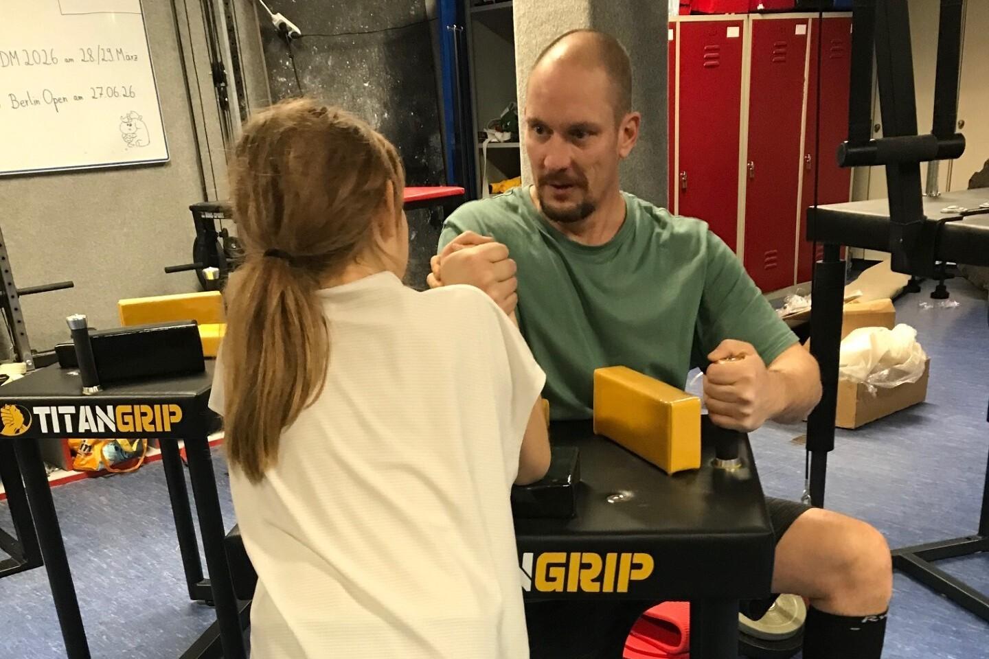 Kind beim Armdrücken an den neuen Tischen