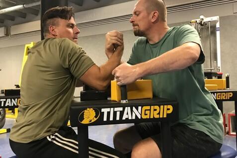 Zwei Männer demonstrieren die Nutzung der neuen Tische für die Armringabteilung, an denen Kinder und Menschen