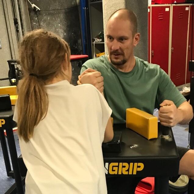 Kind beim Armdrücken an den neuen Tischen