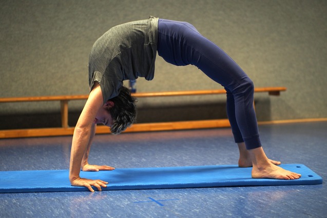 Eine Person macht beim Turntraining eine Br&uuml;cke auf der Matte