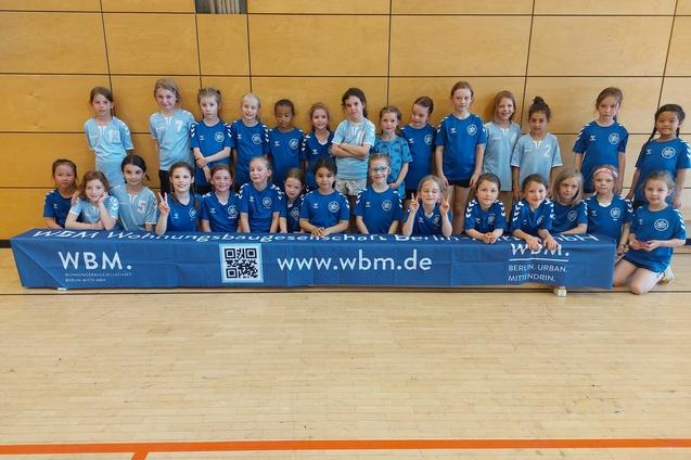 E-Jugend mit WBM Banner Die E-Jugend der Handballabteilung posiert vor einem Spiel mit dem Werbebanner der WBM, von der sie mit gesponsert werden.