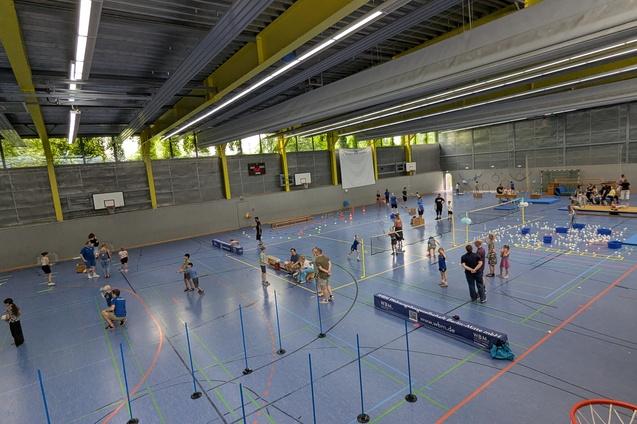 WBM Banner beim Kinderfest Die Sicht vom oberen Rang der Sporthalle in der Samariterstr. 19/20 zeigt das treiben in der Halle beim Kindersportfest. Im Fokus der Werbe-Banner der WBM. Sponsor der Handballabteilung.